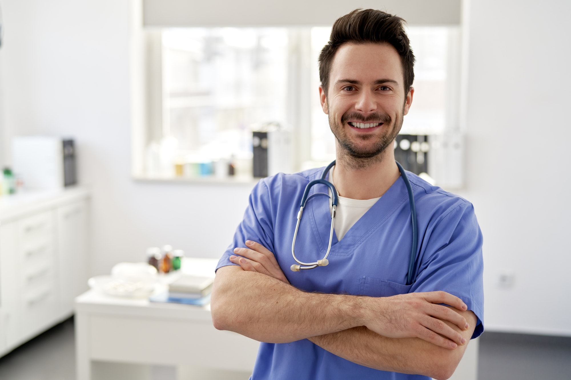 Portrait of young happy doctor in the doctor's office